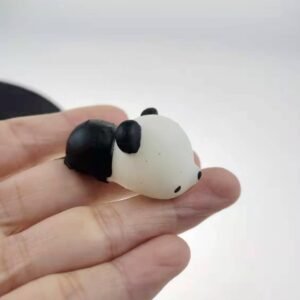 Mini black-and-white panda squishy resting on fingertips