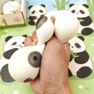 Panda squishy being squeezed with panda display boxes in the background