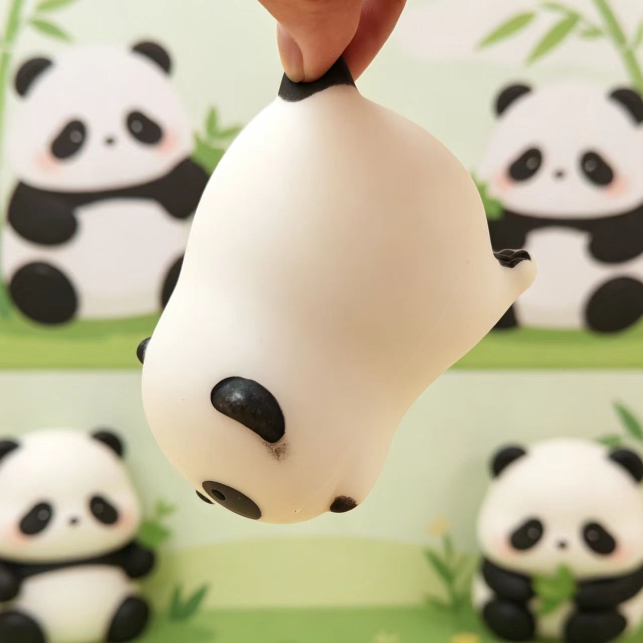 Panda squishy stretched by hand above its display packaging